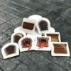 A carefully curated pile of Tactical Tokens featuring illustrations of doors, treasure chests, and mimics emerging from doors and chests. There are 8 illustrated tokens. From left to right, top to bottom: Closed Chest, Closed Door, Open Door, Treasure Chest full of gold, Archway, mimic door, mimic chest, empty chest. The tokens are displayed on a textured gray dungeon-style surface.
